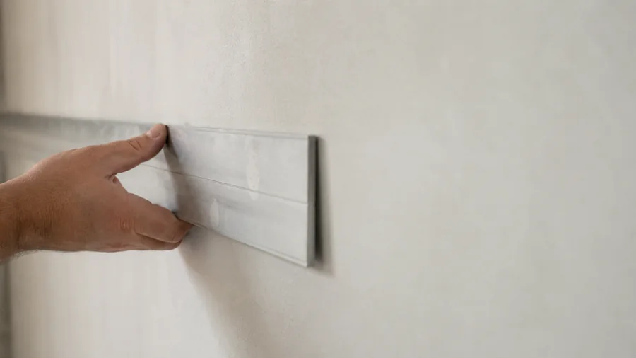Contrôle de planéité d'un mur fini avec une règle appliquée contre la surface